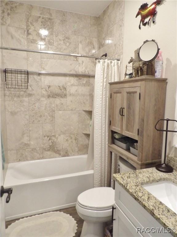 full bathroom featuring shower / bath combo with shower curtain, vanity, hardwood / wood-style floors, and toilet