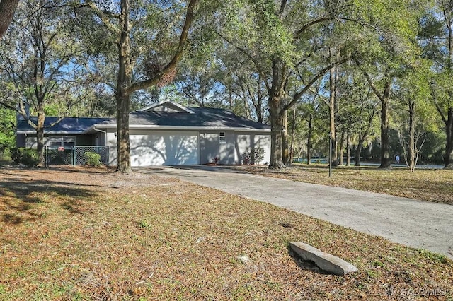 view of front of house with a front lawn, driveway, an attached garage, and fence