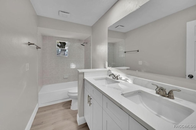 full bathroom featuring double vanity, a sink, toilet, and wood finished floors