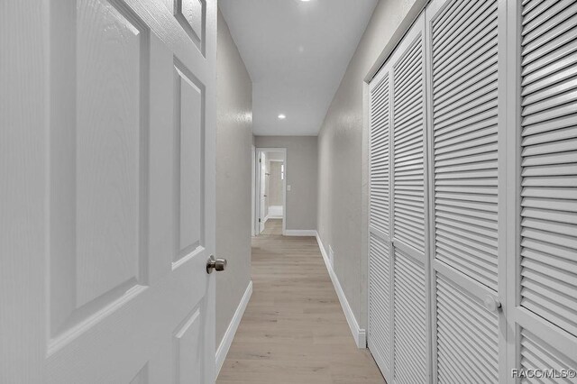 hall featuring recessed lighting, light wood-style flooring, and baseboards