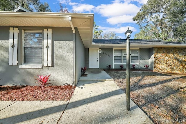 doorway to property featuring stucco siding