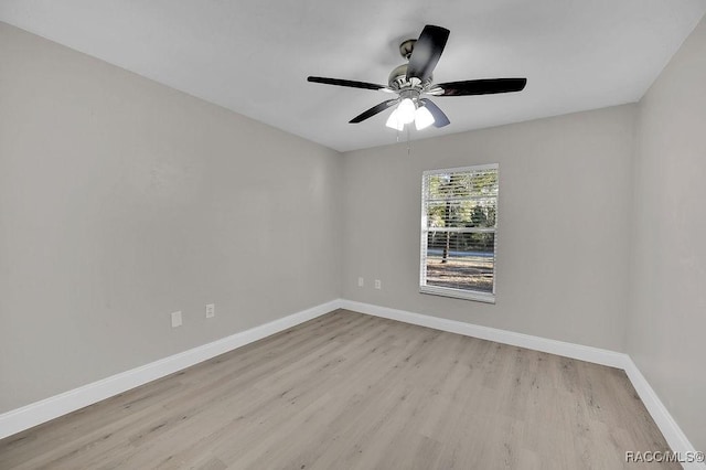 empty room featuring ceiling fan, light wood-style flooring, and baseboards