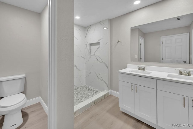 full bath with wood finished floors, a sink, toilet, and double vanity