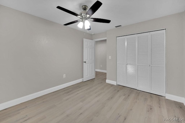 unfurnished bedroom featuring light wood-style floors, a closet, visible vents, and baseboards