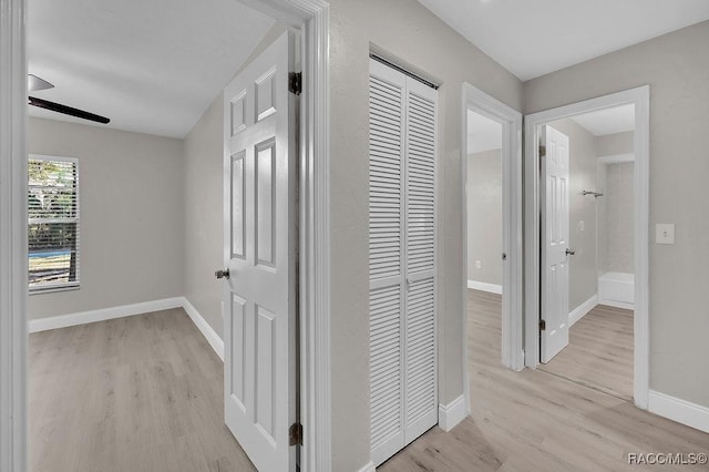 hallway featuring light wood-style floors and baseboards