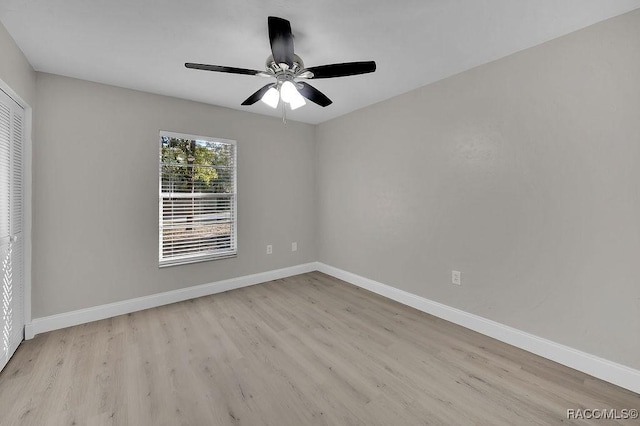 unfurnished bedroom featuring light wood-style flooring, baseboards, ceiling fan, and a closet