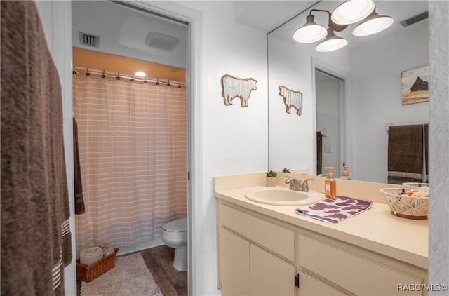 bathroom with hardwood / wood-style flooring, vanity, and toilet