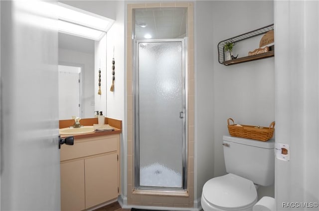 bathroom featuring a skylight, vanity, an enclosed shower, and toilet