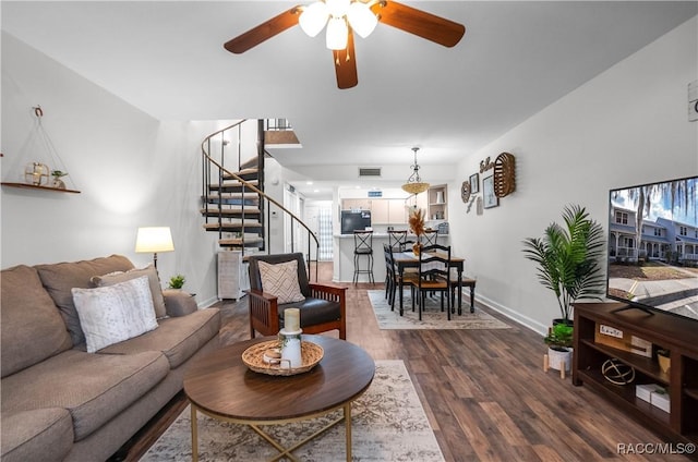 living room featuring ceiling fan and dark hardwood / wood-style floors