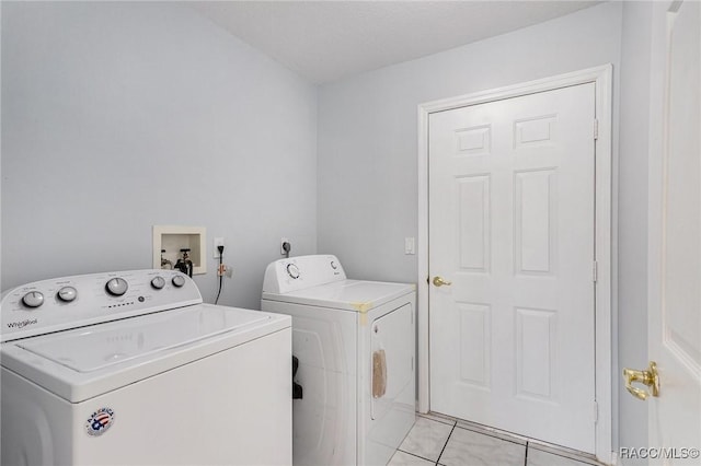 clothes washing area featuring washer and clothes dryer, laundry area, and light tile patterned floors