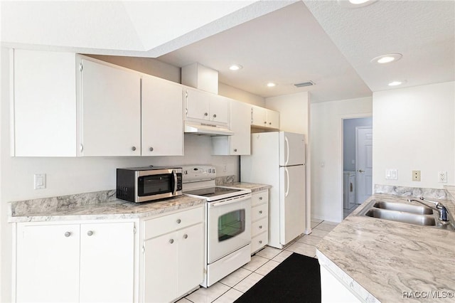 kitchen with visible vents, a sink, under cabinet range hood, white appliances, and light countertops