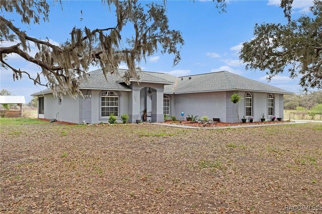 single story home featuring stucco siding and roof with shingles