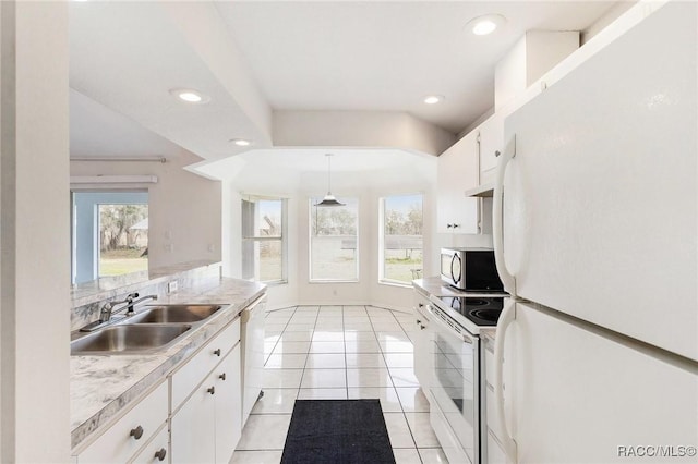 kitchen featuring white appliances, plenty of natural light, light countertops, and a sink