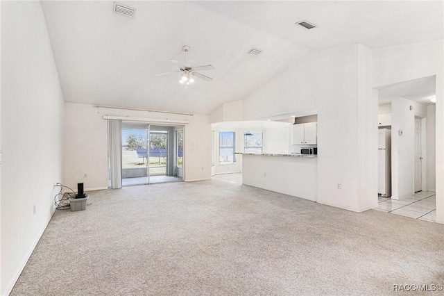 unfurnished living room featuring visible vents, light colored carpet, ceiling fan, and high vaulted ceiling