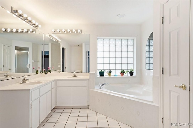 full bathroom with tile patterned flooring, a shower stall, double vanity, a bath, and a sink