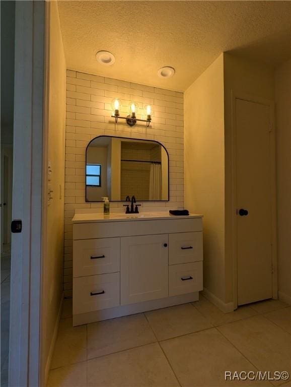 bathroom with vanity, a textured ceiling, and tile patterned floors