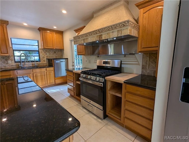 kitchen with sink, custom exhaust hood, plenty of natural light, and appliances with stainless steel finishes