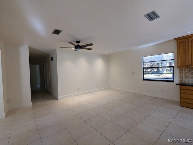 spare room with ceiling fan and light tile patterned floors