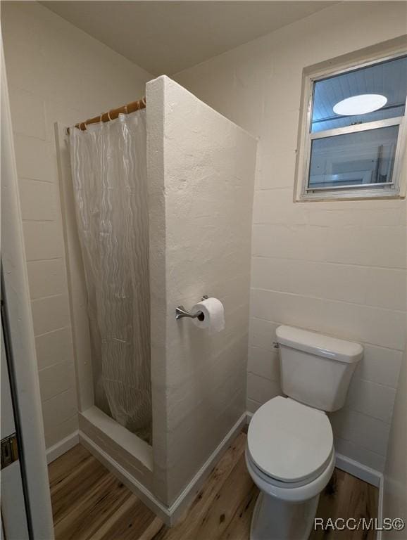 bathroom with toilet, wood-type flooring, and walk in shower