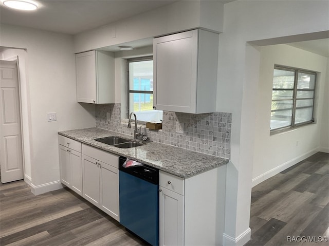 kitchen with stainless steel dishwasher, light stone counters, sink, dark hardwood / wood-style floors, and white cabinetry