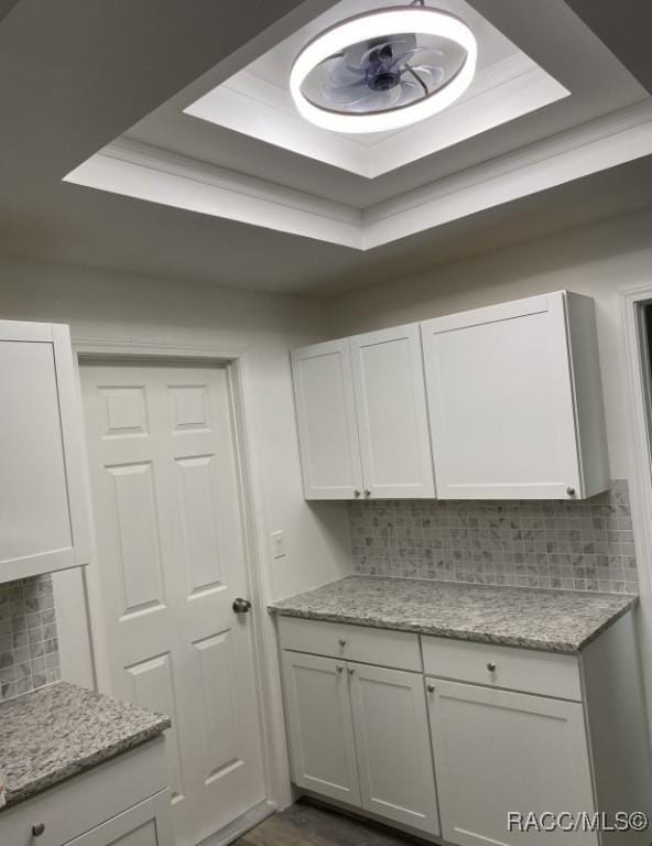 45 S Davis St, Beverly Hills, FL 34465 - kitchen with a raised ceiling, decorative backsplash, white cabinetry, light stone countertops, and dark wood finished floors