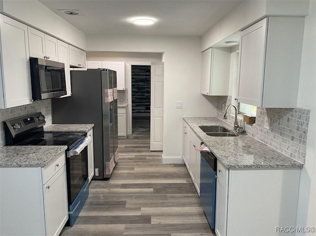 45 S Davis St, Beverly Hills, FL 34465 - kitchen with stainless steel appliances, a sink, wood finished floors, backsplash, and white cabinets