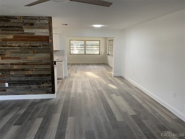 unfurnished living room with ceiling fan and dark hardwood / wood-style flooring