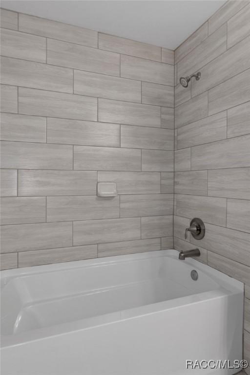 bathroom with bathing tub / shower combination