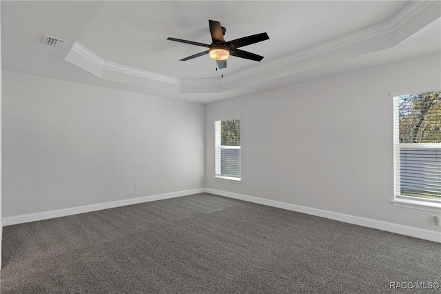 empty room with visible vents, baseboards, a tray ceiling, and ornamental molding