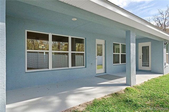 property entrance featuring a patio area and stucco siding