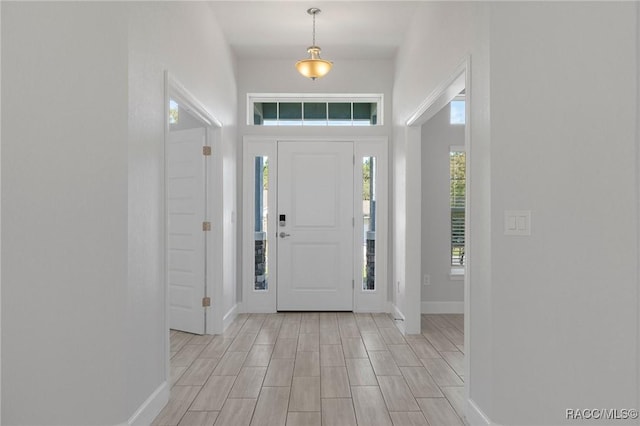 foyer entrance featuring baseboards and light wood-type flooring