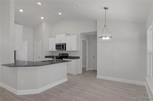 kitchen featuring visible vents, a sink, white cabinetry, stainless steel appliances, and dark stone counters