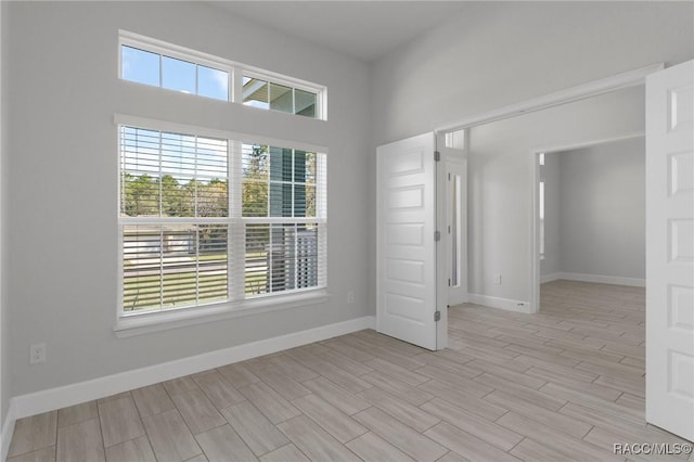 unfurnished room featuring baseboards and light wood finished floors