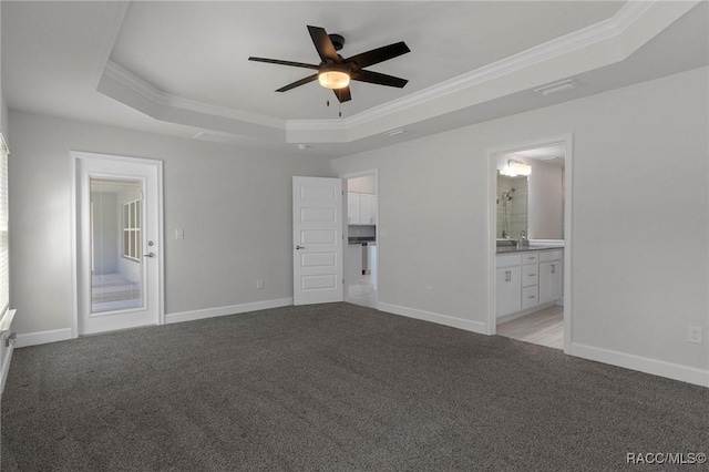 unfurnished bedroom featuring a tray ceiling, crown molding, and light colored carpet