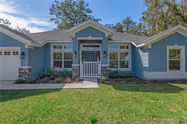 view of front facade with a garage, stucco siding, a front yard, and stone siding