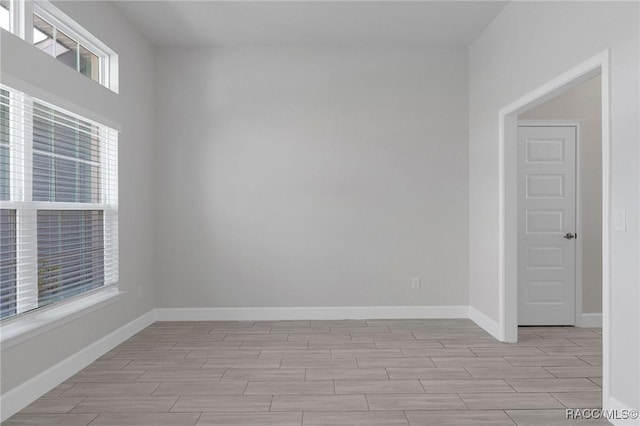 spare room featuring wood finish floors and baseboards