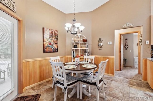 dining area with a healthy amount of sunlight, wooden walls, and a chandelier