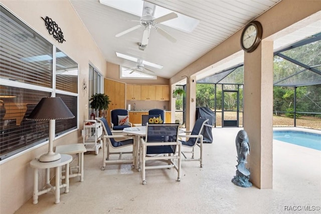 sunroom featuring lofted ceiling with skylight and ceiling fan