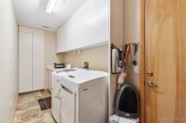 laundry area featuring cabinets and washing machine and clothes dryer