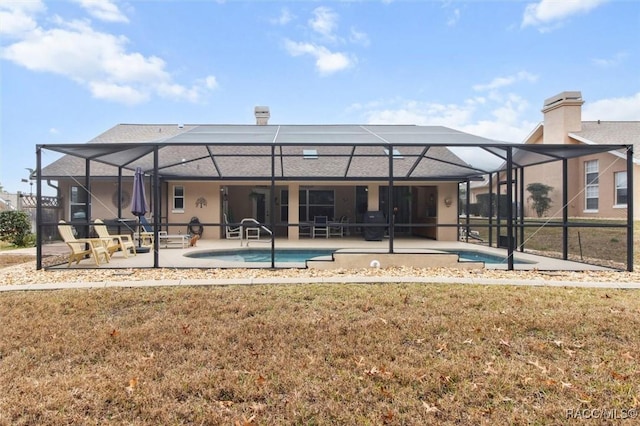 rear view of property featuring a lanai, a patio, and a lawn