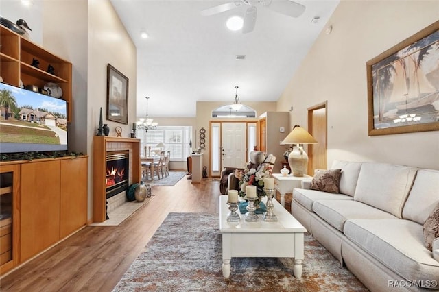 living room with ceiling fan, high vaulted ceiling, and light hardwood / wood-style floors