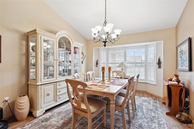 dining space featuring lofted ceiling and an inviting chandelier