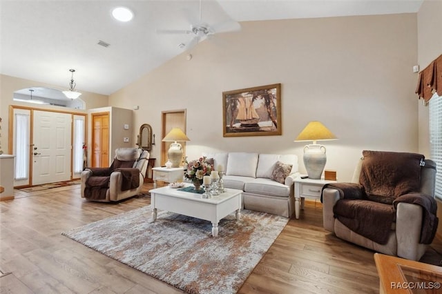 living room featuring ceiling fan, high vaulted ceiling, and light wood-type flooring