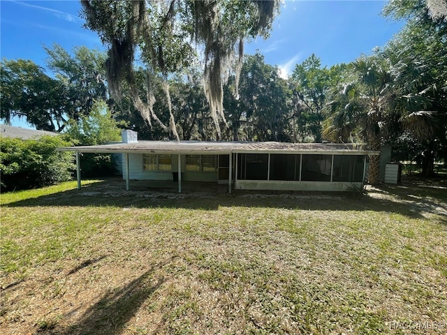 120 NW Magnolia Cir, Crystal River, FL 34428 - rear view of property featuring a sunroom, a lawn, and an attached carport