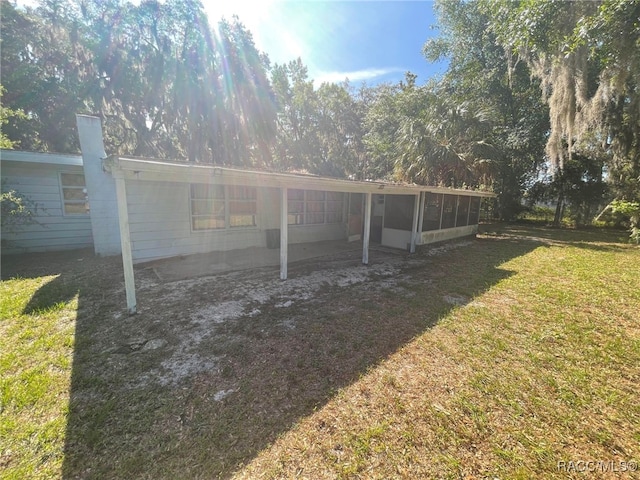 120 NW Magnolia Cir, Crystal River, FL 34428 - rear view of house featuring a sunroom and a lawn