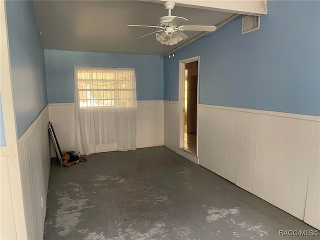 120 NW Magnolia Cir, Crystal River, FL 34428 - empty room featuring concrete flooring, wainscoting, and a ceiling fan