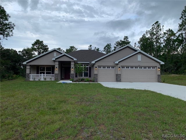 view of front of house featuring a front lawn, covered porch, and a garage