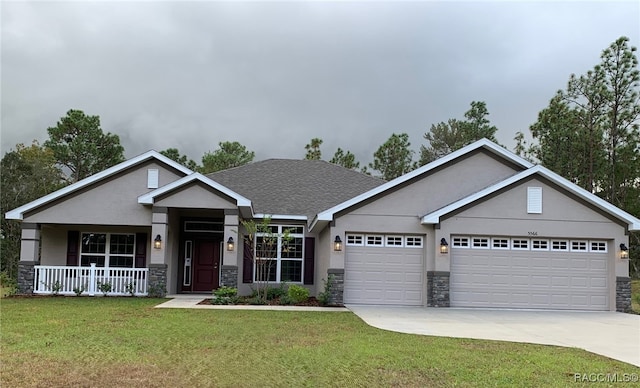 craftsman-style home featuring covered porch, a garage, and a front yard