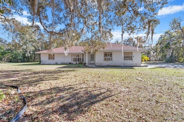 ranch-style house featuring cooling unit and a front lawn