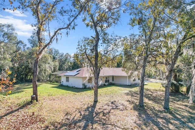 view of property exterior with solar panels and a yard